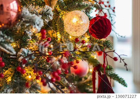 Merry Christmas Xmas happy holidays. Golden ornament decoration ball and defocused garland lights on classic decorated Christmas tree. Christmas tree with red white ornaments. Christmas eve at home 130071227