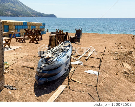 A kayak with paddles placed on sandy beach by the sea. Adventure, leisure and summer recreation at the coastal shoreline. 130071508