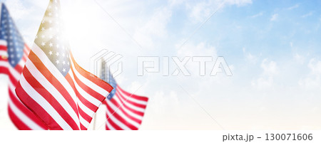 Ideal patriotic image for Veterans Day, military tribute, national celebrations, and Independence Day projects. USA flags fluttering against clear sky, representing honor, respect, and remembrance. 130071606