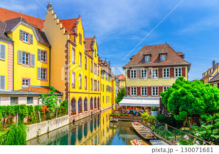 Old houses colorful facade, medieval buildings multicolored walls on bank of river Lauch canal with boats on water, old town Colmar city historic centre in summer day, Alsace Grand Est region, France 130071681