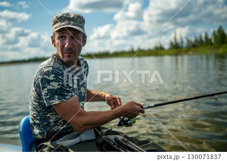 Close-up of an elderly fisherman fishing with a spinning rod Close-up of an elderly fisherman fishing with a spinning rod 130071837