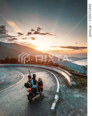 happy romantic couple in love on motorcycle in mountains, adventure and joyful freedom, lovely pair riding bike in rugged peaks, passionate journey and scenic excitement 130071848