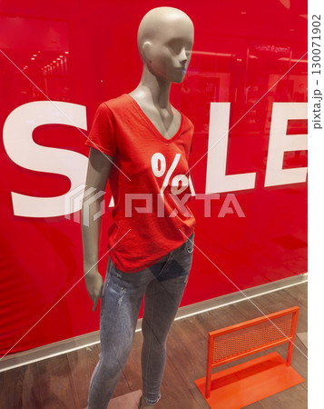 Mannequin displaying stylish red shirt in vibrant sale setting at mall Mannequin displaying stylish red shirt in vibrant sale setting at mall 130071902