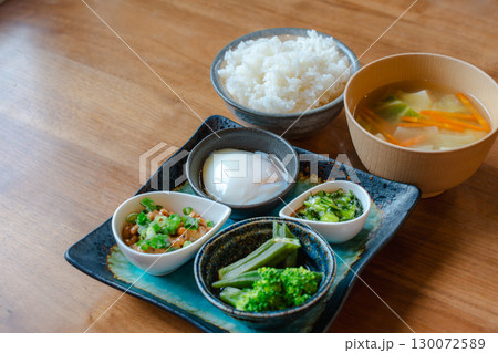 ご飯と味噌汁に納豆や温泉卵、野菜の小鉢を添えた和風朝食セット 130072589