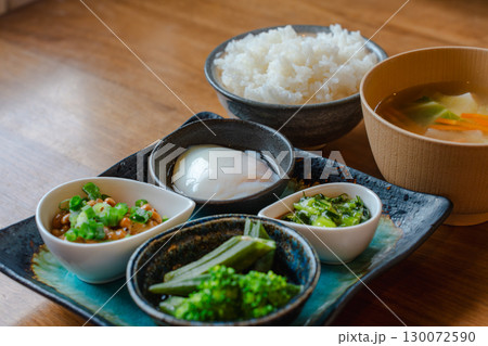 ご飯と味噌汁に納豆や温泉卵、野菜の小鉢を添えた和風朝食セット 130072590