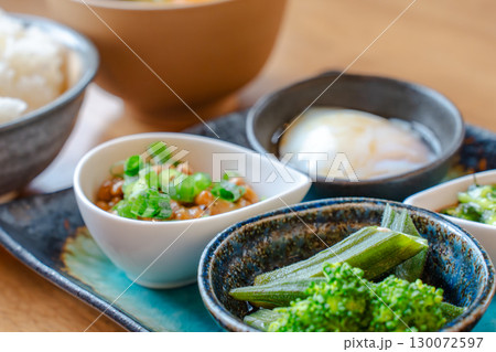 ご飯と味噌汁に納豆や温泉卵、野菜の小鉢を添えた和風朝食セット ご飯と味噌汁に納豆や温泉卵、野菜の小鉢を添えた和風朝食セット 130072597