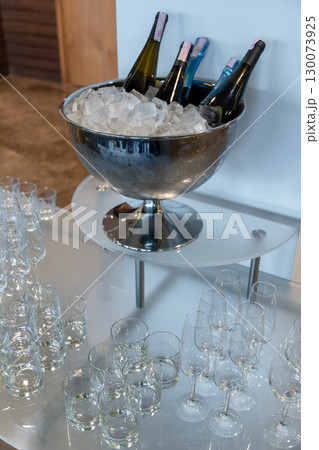 Elegant banquet setup with wine and champagne bottles chilling in a large ice bowl 130073925