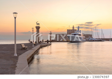 Mandraki Harbour in Rhodes, Greece at sunset 130074397