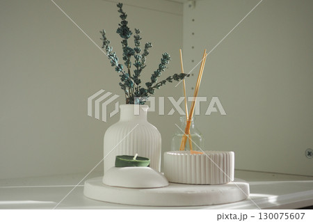 Display of minimalistic home decor with candles and plants 130075607