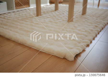 Cozy textured rug under a dining table in a bright room Cozy textured rug under a dining table in a bright room 130075646