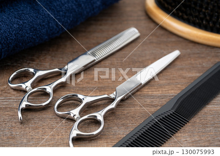 散髪用のはさみとすきばさみと櫛とヘアブラシのセットのクローズアップ 130075993