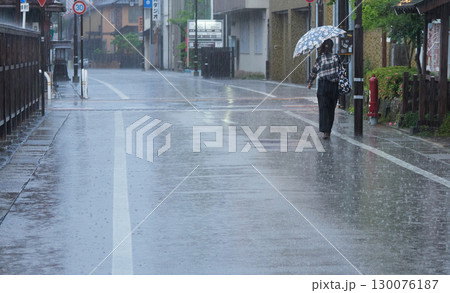 雨の日に観光名所高山市の街で歩く一人の若い女性の姿 雨の日に観光名所高山市の街で歩く一人の若い女性の姿 130076187