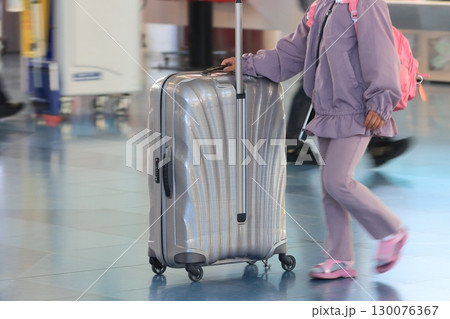 空港でスーツケースを引く旅行者 カートに荷物を積んで移動する旅行者 空港でスーツケースを引く旅行者 カートに荷物を積んで移動する旅行者 130076367