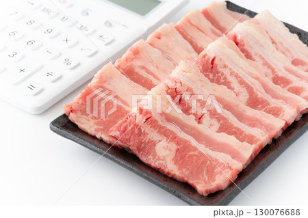 アメリカ産の牛カルビ肉(牛バラ肉)と電卓のクローズアップ アメリカ産の牛カルビ肉(牛バラ肉)と電卓のクローズアップ 130076688