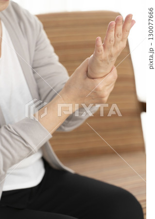 手の痛みこわばりに悩むシニア女性の手 130077666
