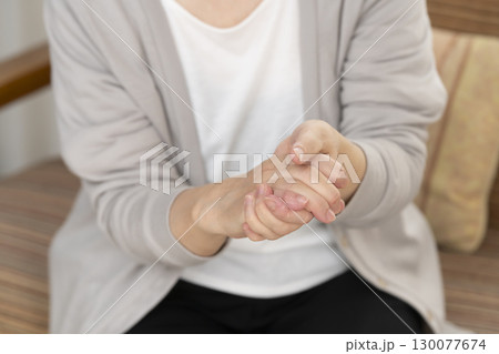 手の痛みこわばりに悩むシニア女性の手 130077674