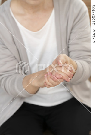 手の痛みこわばりに悩むシニア女性の手 130077675