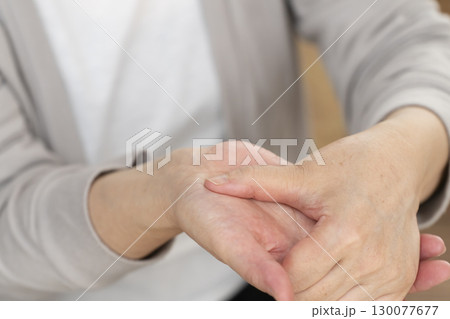 手の痛みこわばりに悩むシニア女性の手 130077677