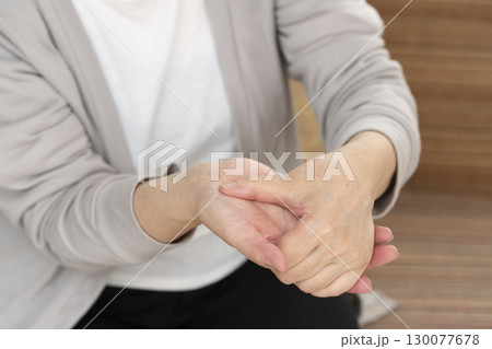 手の痛みこわばりに悩むシニア女性の手 130077678