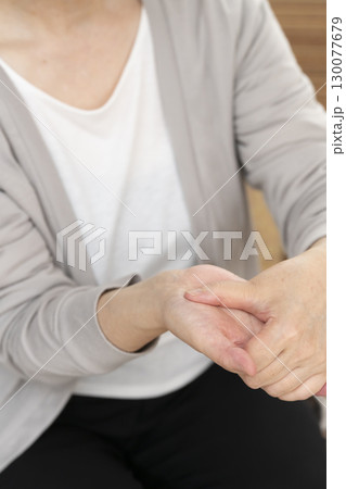 手の痛みこわばりに悩むシニア女性の手 130077679