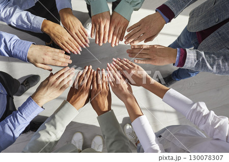 Team of diverse, multiracial business people joining and holding their hands together Team of diverse, multiracial business people joining and holding their hands together 130078307