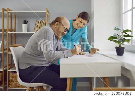 Smiling young female nurse, doctor or caregiver consulting cheerful senior man. Smiling young female nurse, doctor or caregiver consulting cheerful senior man. 130078308