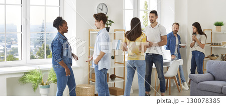 Multiracial group of friends people enjoying home party with snacks and drinks 130078385