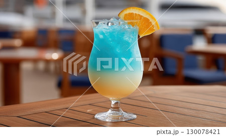 Refreshing Vibrant Cocktail Served in Curvy Glass with Ice and Orange Slice on Summer Table Setting 130078421