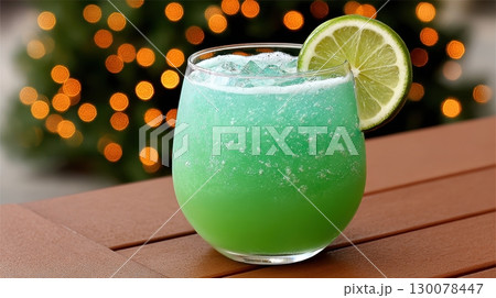 Chilled Green Cocktail in Curvy Glass with Lime Garnish Against Soft Glowing Background 130078447