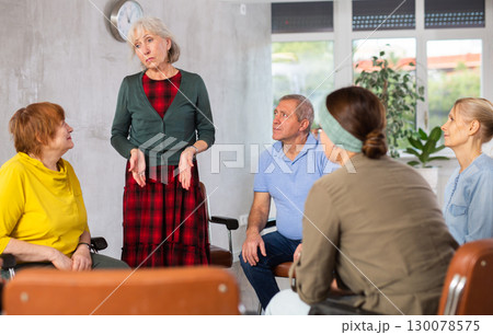 Unhappy senior woman talking during group psychological therapy Unhappy senior woman talking during group psychological therapy 130078575