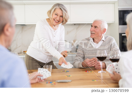 Group of friends playing poker cards and drinking wine at home Group of friends playing poker cards and drinking wine at home 130078599
