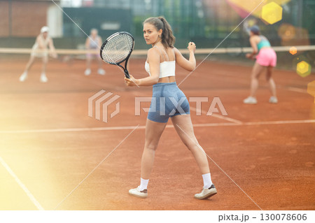 Two young women playing tennis against elderly women 130078606