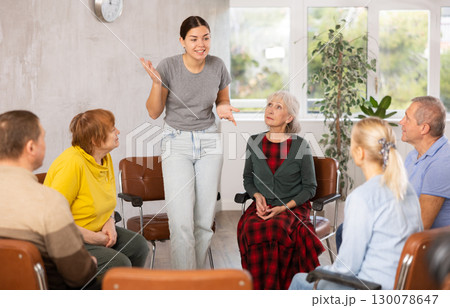 Young woman doing group training for mature people 130078647