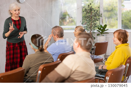 Elderly female tutor teaching group of mature students Elderly female tutor teaching group of mature students 130079045