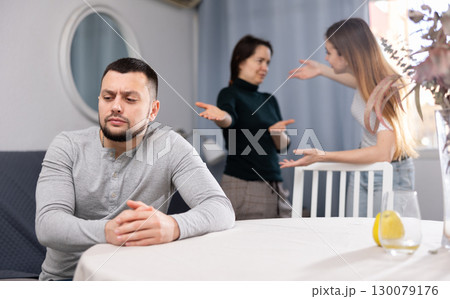 Man waiting for two women stop quarreling 130079176