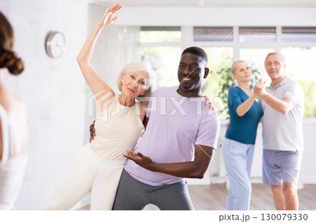African-American man dances steamy salsa with elderly female companion for fitness classes African-American man dances steamy salsa with elderly female companion for fitness classes 130079330
