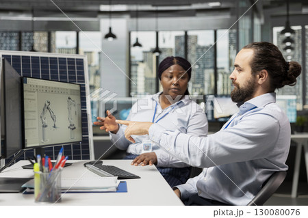 Team working together in office to optimize sustainable solar panel fabrication with advanced assembly lines. Coworkers innovate clean solar energy equipment manufacturing processes 130080076