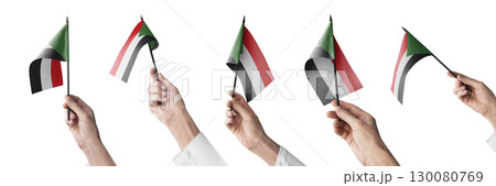 The Sudan flag in hand in different angles on a white background 130080769