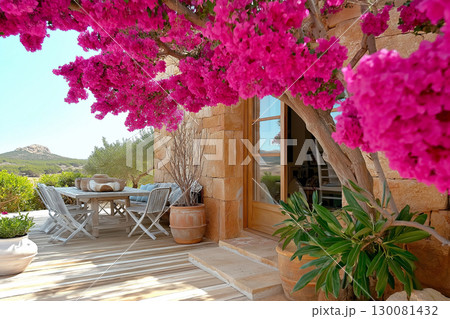 Gorgeous garden atrium in Ibiza style with olive tree and vibrant flowers 130081432