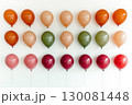 Colorful balloons arranged neatly on a white wall for a festive celebration atmosphere 130081448