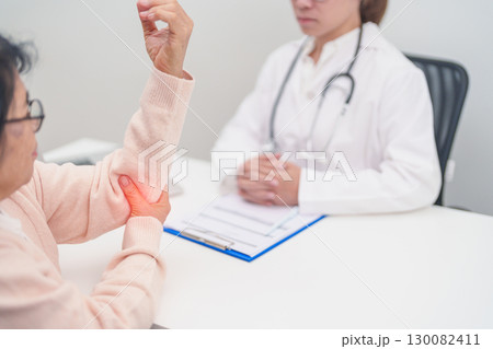 Elderly Woman having elbow ache and consulting doctor in hospital. muscle pain due to lateral epicondylitis or tennis elbow. injury, Health and medical consultation concept Elderly Woman having elbow ache and consulting doctor in hospital. muscle pain due to lateral epicondylitis or tennis elbow. injury, Health and medical consultation concept 130082411