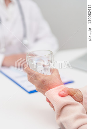 Senior woman with Tremor hand during taking glass of water in hospital. Parkinson disease April awareness month, Carpal Tunnel Syndrome, rheumatoid and brain injury and Neurological disorder concept 130082413