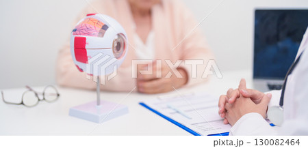 Elderly Patient consulting Doctor to Eye disease, Senior Medical Diagnosis. Anatomy Eye model for Cataract, Glaucoma, Age Related Macular Degeneration, Diabetic Retinopathy, Vitreous, health concept 130082464