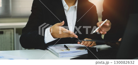 Business professionals discussing financial reports and data on digital tablet 130082632