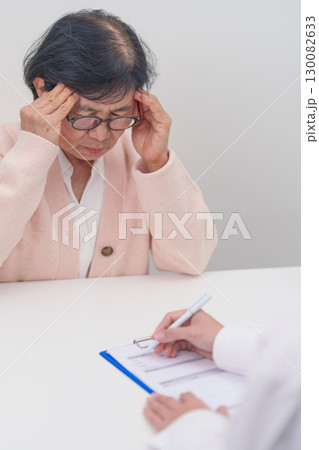 Senior Woman having headache and consulting doctor to disease. Elderly health patient, Medical Diagnosis, Migraine, Brain Tumor, Brain Stroke, Dementia, neurological disorder, alzheimer, Parkinson Senior Woman having headache and consulting doctor to disease. Elderly health patient, Medical Diagnosis, Migraine, Brain Tumor, Brain Stroke, Dementia, neurological disorder, alzheimer, Parkinson 130082633