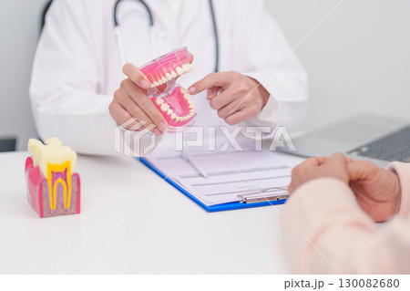 Elderly Patient consulting Dentist to Tooth disease, Senior Health Medical Diagnosis. Anatomy teeth model for Oral Teeth decay, Scrape off tartar. March Oral health, Dentist Day, False Teeth concept Elderly Patient consulting Dentist to Tooth disease, Senior Health Medical Diagnosis. Anatomy teeth model for Oral Teeth decay, Scrape off tartar. March Oral health, Dentist Day, False Teeth concept 130082680