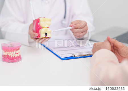 Elderly Patient consulting Dentist to Tooth disease, Senior Health Medical Diagnosis. Anatomy teeth model for Oral Teeth decay, Scrape off tartar. March Oral health, Dentist Day, False Teeth concept Elderly Patient consulting Dentist to Tooth disease, Senior Health Medical Diagnosis. Anatomy teeth model for Oral Teeth decay, Scrape off tartar. March Oral health, Dentist Day, False Teeth concept 130082683