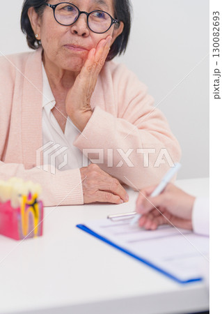 Elderly Patient consulting Dentist to Tooth disease, Senior Health Medical Diagnosis. Anatomy teeth model for Oral Teeth decay, Scrape off tartar. March Oral health, Dentist Day, False Teeth concept Elderly Patient consulting Dentist to Tooth disease, Senior Health Medical Diagnosis. Anatomy teeth model for Oral Teeth decay, Scrape off tartar. March Oral health, Dentist Day, False Teeth concept 130082693
