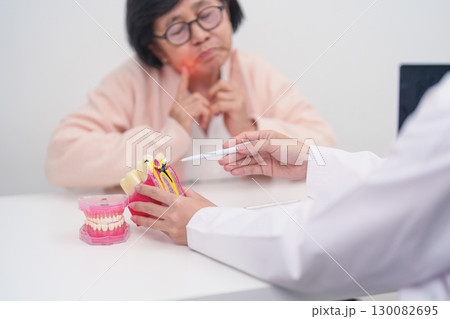Elderly Patient consulting Dentist to Tooth disease, Senior Health Medical Diagnosis. Anatomy teeth model for Oral Teeth decay, Scrape off tartar. March Oral health, Dentist Day, False Teeth concept Elderly Patient consulting Dentist to Tooth disease, Senior Health Medical Diagnosis. Anatomy teeth model for Oral Teeth decay, Scrape off tartar. March Oral health, Dentist Day, False Teeth concept 130082695