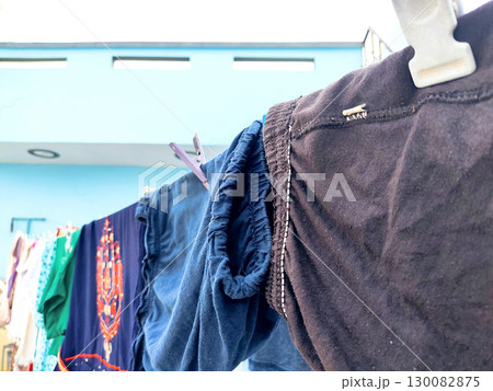 Clothes Drying on a Rope Against Blue Wall Outdoors Clothes Drying on a Rope Against Blue Wall Outdoors 130082875